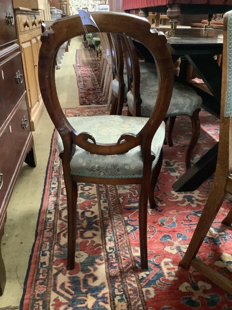 A set of four Victorian walnut balloon back dining chairs